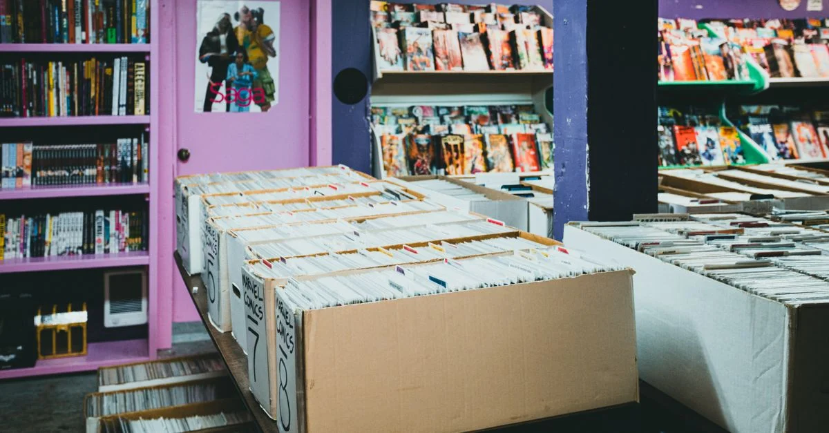Une librairie de bandes dessinées colorée avec des étagères organisées et des boîtes de bandes dessinées à vendre.