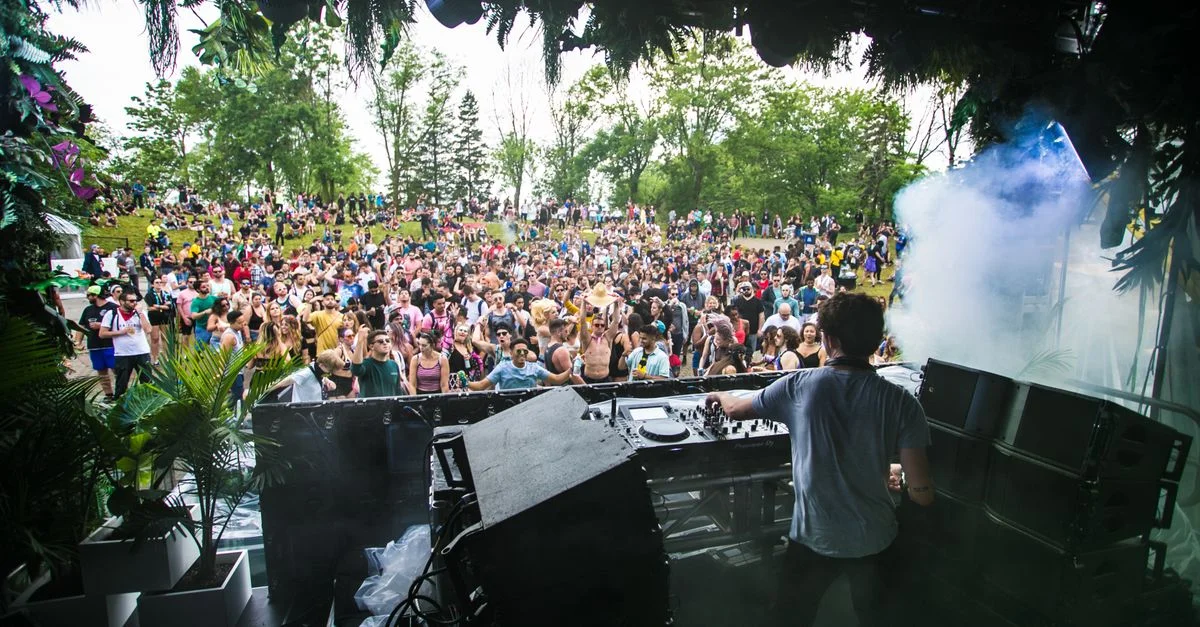 DJ se produisant devant une foule animée lors d'un festival de musique en plein air.